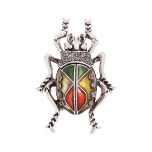 Detail van een zilveren keverbroche met kleurrijke emaille vleugels en strass-stenen