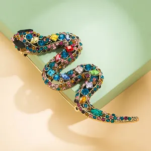 Gedetailleerde close-up van een gouden slangenbroche met veelkleurige kristallen.