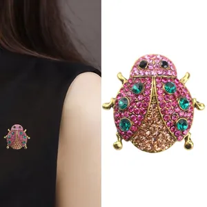 Broche coccinelle scintillante avec strass roses et verts pour accessoires de mode chic.