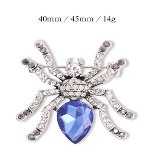 Gedetailleerd overzicht van een spinnenbroche met blauw kristal en heldere strass