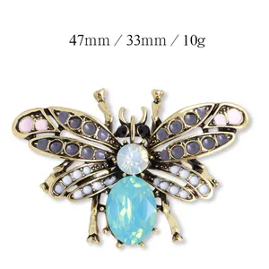 Macro detail van een insectenbroche met blauw kristal en strass steentjes 47mm x 33mm