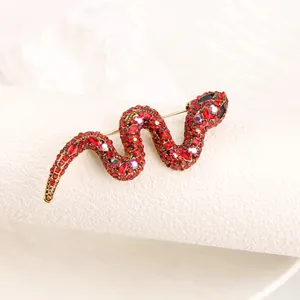 Elegante vintage slangenspeld broche met rode kristallen en sprankelende strass-stenen