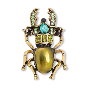 Vintage goudkleurige keverbroche met groene kristallen strass insectenspeld