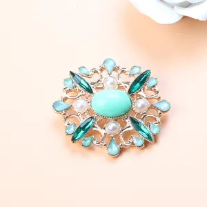 Elegant macro view of a vintage Baroque brooch featuring green crystals and white pearls