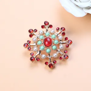 Detailed view of luxury vintage Baroque brooch with red gems and pearls on gold alloy