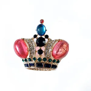 Detaillierte Makroansicht der Vintage-Kronenbrosche mit bunten Edelsteinen und Strass