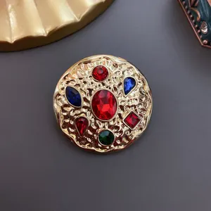 Detailed macro shot of a vintage gold-toned brooch with colorful multi-shape gemstones.