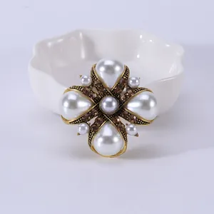 Gedetailleerd vooraanzicht van vintage kruisbroche met witte parels en kristallen