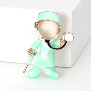 Macro view of a cute mint green cartoon doctor brooch featuring a cat eye stone head.