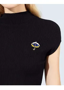 Close-up of a creative starry sky umbrella brooch pinned on a black ribbed sweater.