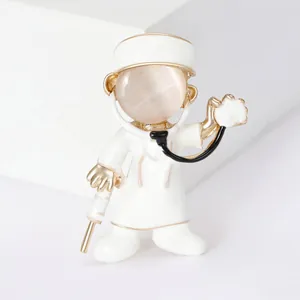Macro detail view of white enamel angel doctor brooch with beige cat's eye stone face