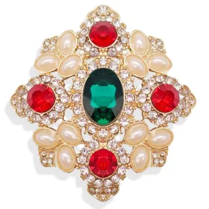 Exquisite close-up view of vintage Baroque emerald green brooch with red and pearl accents