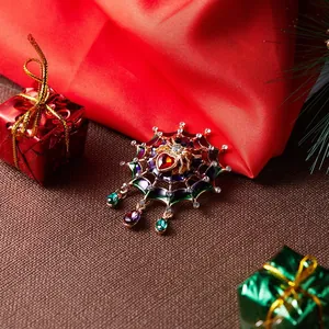 Close-up detail of a creative spiderweb brooch with colorful enamel and sparkling rhinestones.