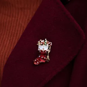 Detail view of a vintage-style Christmas stocking brooch with red enamel and shiny crystals