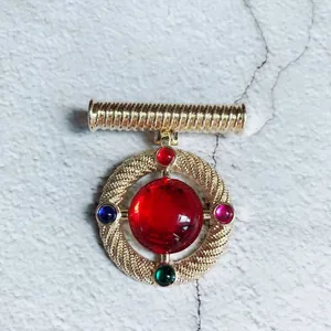 Close-up of a vintage Baroque palace style brooch with a large central red stone