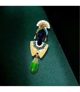 Macro view of vintage exotic African chieftain wife portrait brooch with green crystal drop