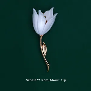 Vista dettagliata della spilla a tulipano bianco con stelo e foglia d'oro