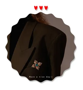 Gedetailleerde close-up van een vintage barokke bloemenspeld op een donkere blazer