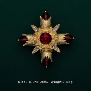 Detailed close-up of a vintage Baroque gold brooch featuring a large red central gemstone.