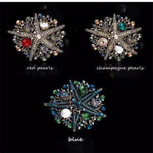 Vintage rhinestone starfish brooches available in red, champagne, and blue colors