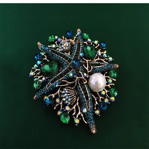Close-up of a vintage starfish brooch featuring blue rhinestones and a large white pearl