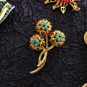 Close-up view of a luxury vintage baroque brooch with colorful rhinestones and gold finish