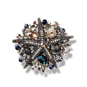 Vintage starfish brooch with colorful crystals and pearls on a plain white background