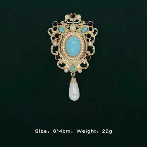 Detailed view of Baroque vintage gold brooch with turquoise and teardrop pearl pendant