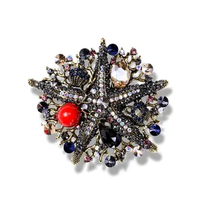 Macro view of a vintage oversized starfish brooch with colorful rhinestones and red pearl