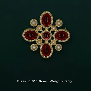 Detail view of Baroque vintage gold brooch with red gemstones and white pearls