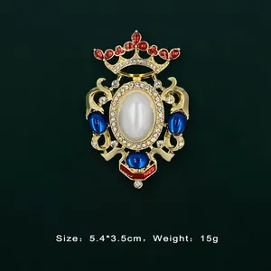 Detailed view of a vintage Baroque gold brooch with crown design and colorful gemstones