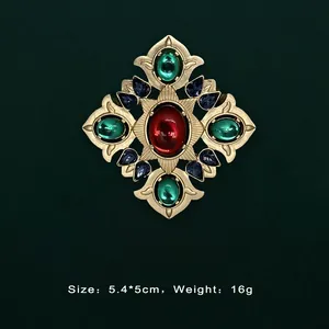 Close-up of Baroque vintage gold brooch with colorful gemstones on dark background