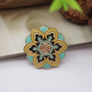 Close-up of a vintage baroque enamel flower brooch with teal and yellow accents