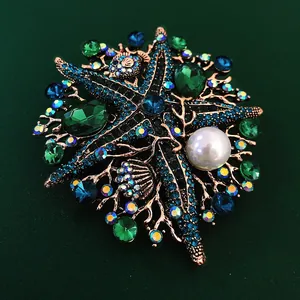 Elegant vintage starfish brooch with blue and green rhinestones and a white pearl