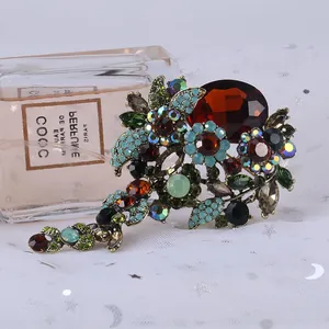 Detail of vintage flower brooch with multicolored rhinestones and large amber gem.