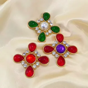 Detailansicht von Vintage-Kreuzbrosche mit farbigen Glassteinen und Kristallen