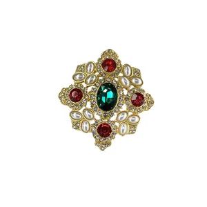 Gedetailleerd overzicht van barokke vintage broche met smaragdgroene steen en parels