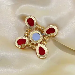 Detailansicht der Rückseite einer Vintage Kreuzbrosche mit sicherem Nadelverschluss und Glas.