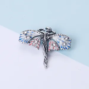 Macro-detail van een vintage engelbroche met kleurrijke emaille vleugels en kristal