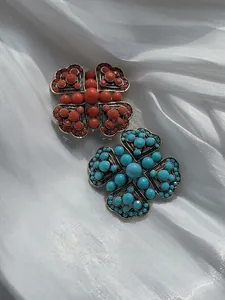Macro detail of vintage Turkish style flower brooches with red and turquoise beads