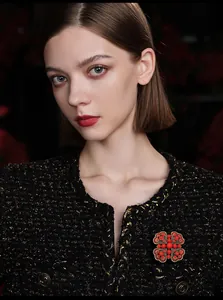 Close-up of vintage heart-shaped red brooch pinned on elegant black tweed jacket