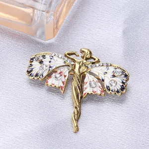 Detailweergave van een vintage gouden feeënspeld met geëmailleerde vlindervleugels en kristallen.