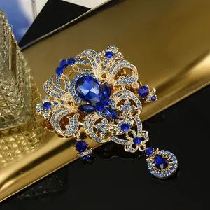 Détail macro d'une broche couronne en alliage doré avec strass bleus en forme de goutte