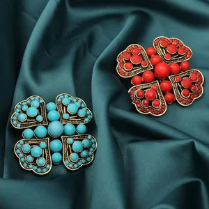 Macro detail of vintage Turkish style brooches in red and turquoise blue