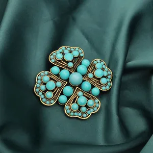 Detailed macro view of a vintage Turkish blue beaded brooch with antique gold heart-to-heart design