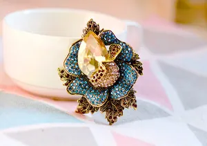Detailed view of elegant crystal flower brooch with yellow teardrop glass and blue rhinestones