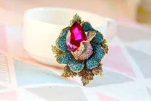 Detailed view of elegant flower brooch with blue crystals and pink centerpiece