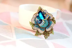 Close-up of luxury floral brooch with blue crystals and gold-tone zinc alloy