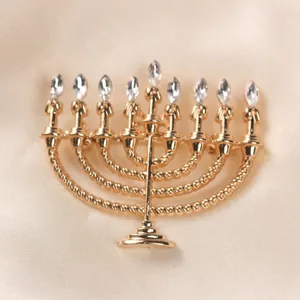 Close-up detail of a vintage gold Hanukkah Menorah brooch adorned with clear crystals