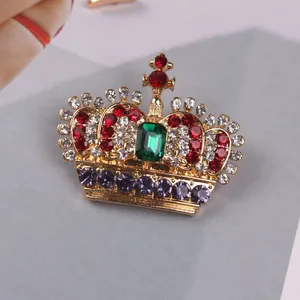 Close-up detail of luxury crown brooch featuring vibrant multicolor rhinestones.